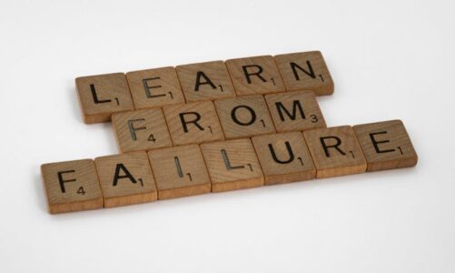 Drewniane płytki do gry w Scrabble układające się w hasło „Learn from failure”.