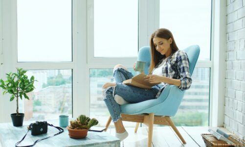 kobieta siedząca na fotelu i czytająca książkę